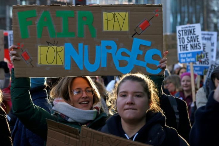 People hold placards as they take part in a protest march to Downing Street in London in support of the pay disputes.