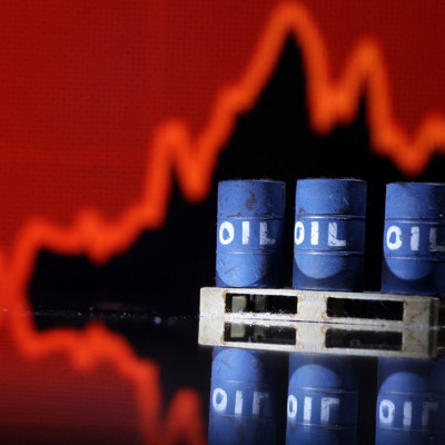 Illustration shows Oil barrels in front of rising stock graph