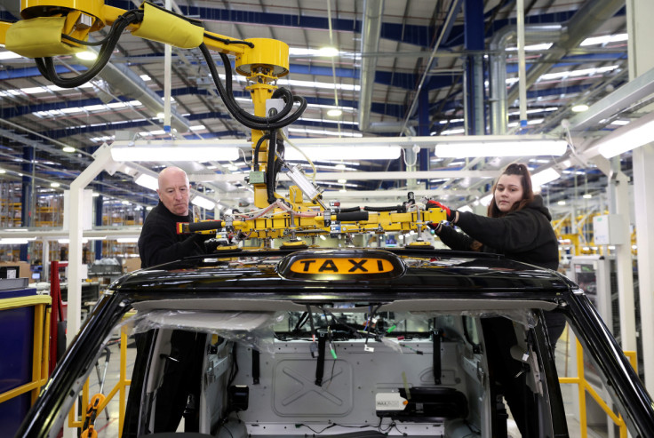 Workers fit a roof panel on the TX electric taxi production line inside the LEVC (London Electric Vehicle Company) factory in Coventry