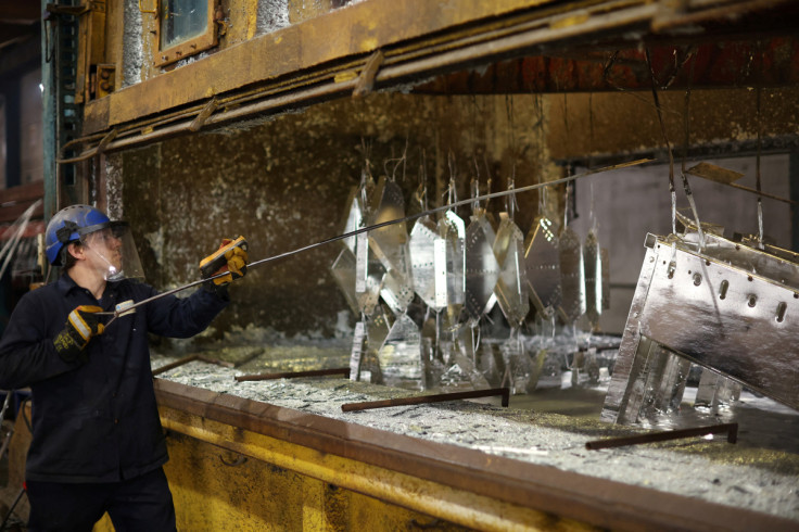 Worker removes pieces of metal from the galvanising bath inside the factory of Corbetts The Galvanizers in Telford
