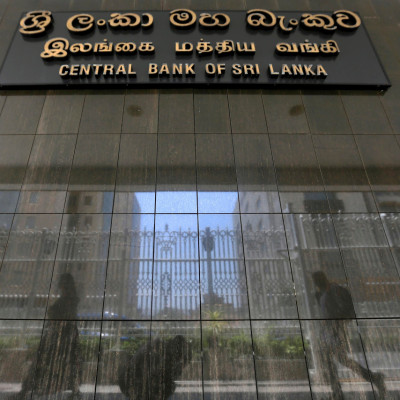 People walk past the main entrance of the Sri Lanka's Central Bank in Colombo, Sri Lanka