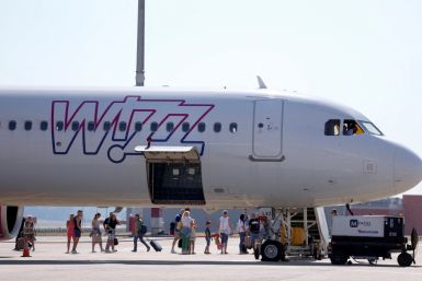 People stand next to a Wizz Air aircraft at Ferenc Liszt International Airport in Budapest
