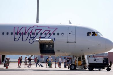 People stand next to a Wizz Air aircraft at Ferenc Liszt International Airport in Budapest