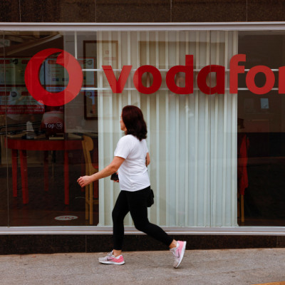 A woman walks past a Vodafone store in Ronda