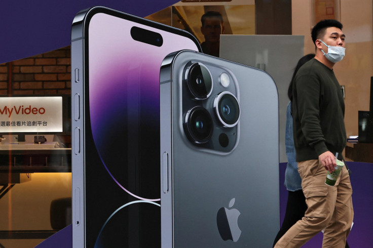 People walk past a poster of iPhones in Taipei,