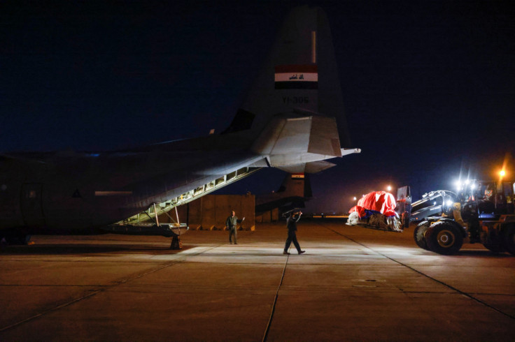 Workers and security forces process aid from Red Crescent that will be shipped on a plane of emergency relief to Syria to support victims of the deadly earthquake, at a military airbase near Baghdad International Airport, in Baghdad