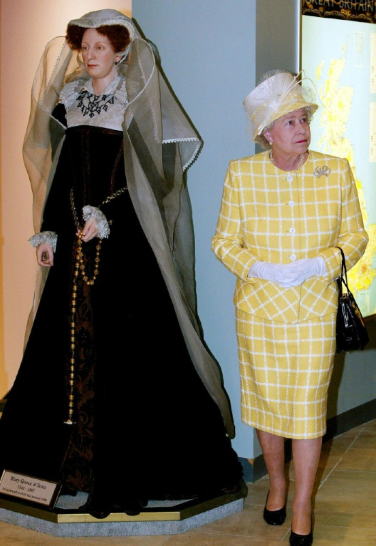 Queen Elizabeth II pictured in 2003 walking past a model of Mary, Queen of Scots