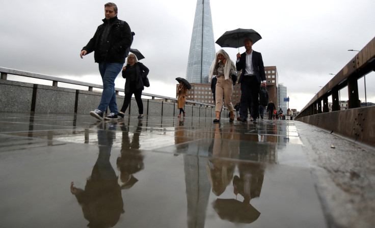 Commuters walk across London Bridge toward the financial district, in London