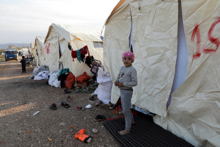A child stands outside tents erected for people affected by a devastating earthquake, in Jandaris
