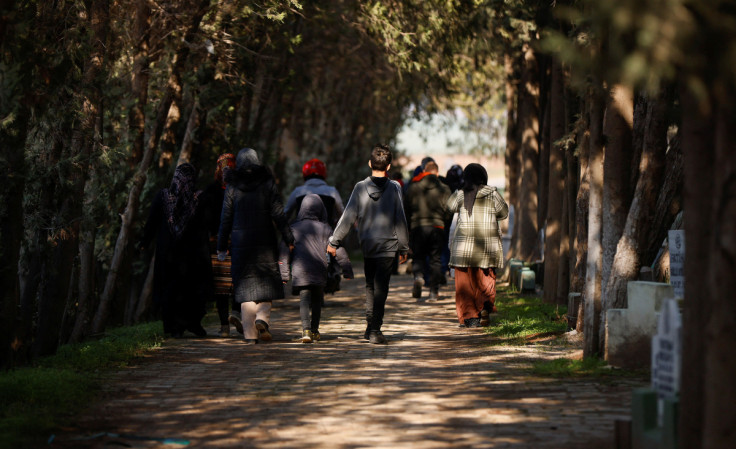 People walk in a cemetery to bury their loved ones, in the aftermath of the deadly earthquake, in Reyhanli