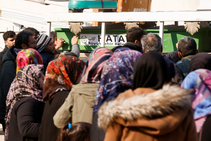 People gather around coffins placed in a vehicle, following the deadly earthquake, in Reyhanli