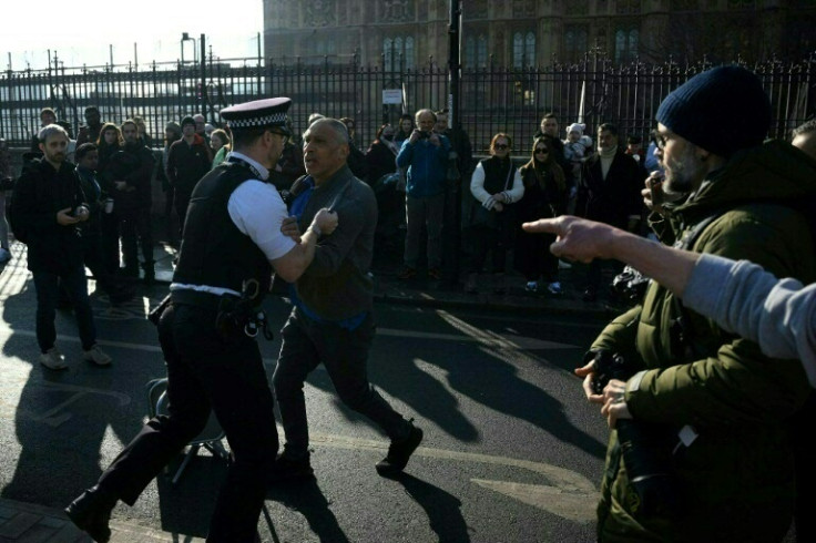 A police officer grapples with a member of the public as climate activists blocked Westminister Bridge, London