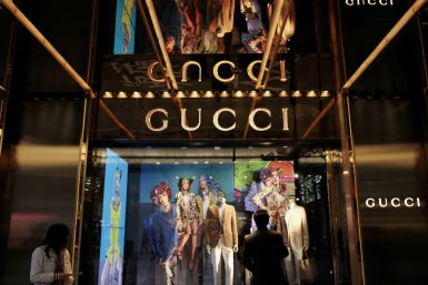 Man watches in front of window display outside a Gucci store in Hong Kong