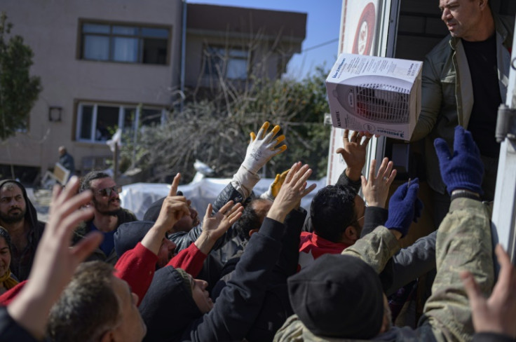 Desperate residents grab food, clothes and household items handed out by a private donor