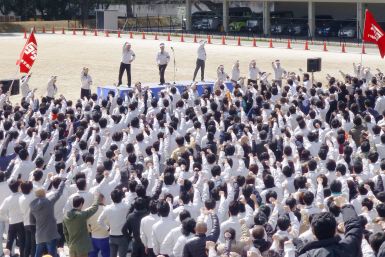 Members of the workers' union of Toyota Motor Corp. raise their fists as they shout slogans during a rally for the annual "shunto" wage negotiations at the company headquarters in Toyota