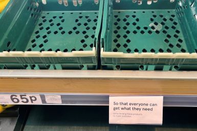 A sign limiting customers to three items each is seen next to empty boxes in the tomato and peppers section inside a Tesco supermarket in Manchester