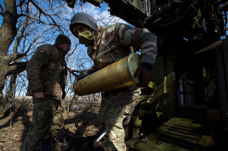 Ukrainian serviceman carries a shell for a 2S5 Giatsint-S self-propelled howitzer before firing towards Russian troops outside the frontline town of Bakhmut