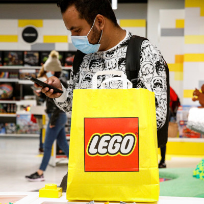 A customer uses his phone while shopping in the 5th Avenue Lego store in New York