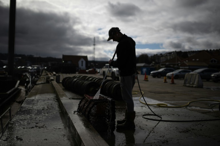 Deck hand Ben Hinchley cleans lobster pots before heading out to sea off Whitby