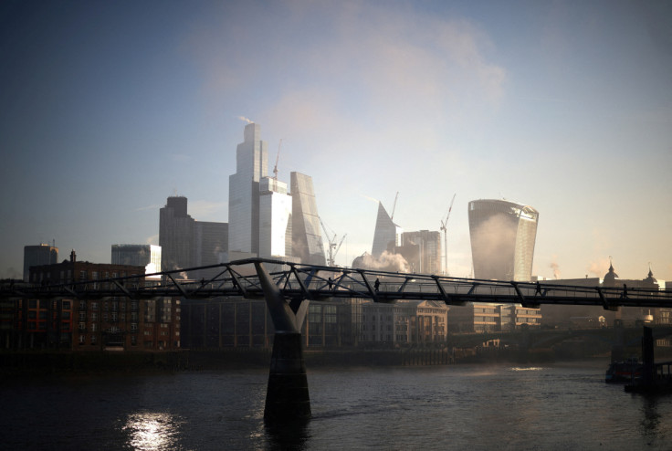 People walk over Millennium Bridge amidst early morning fog as the sun rises in London