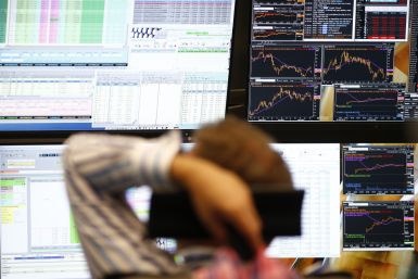 A trader sits in front of the computer screens at his desk at the Frankfurt stock exchange