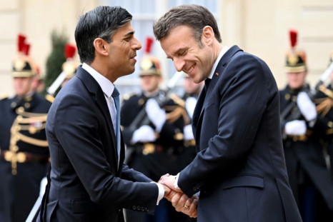 France's President Emmanuel Macron shakes hands with Britain's Prime Minister Rishi Sunak as he arrives at the Elysee Palace