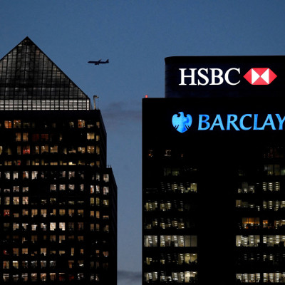 Workers are seen in offices of HSBC and Barclays bank in the Canary Wharf financial district at dusk in London
