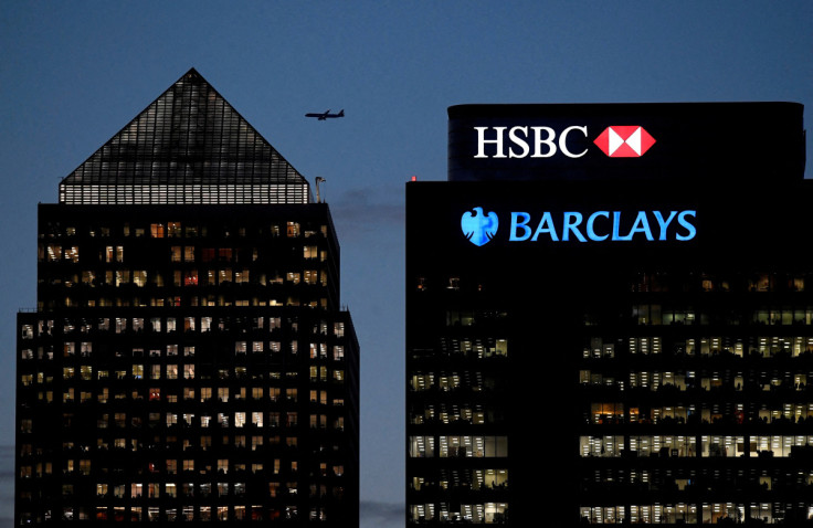 Workers are seen in offices of HSBC and Barclays bank in the Canary Wharf financial district at dusk in London