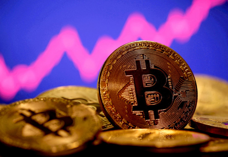 A representation of virtual currency Bitcoin is seen in front of a stock graph in this illustration