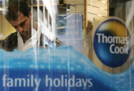 A man looks at a travel brochure of travel company Thomas Cook in London