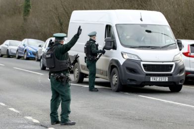 Northern Irish police stop traffic at the scene of the shooting of a senior officer last month