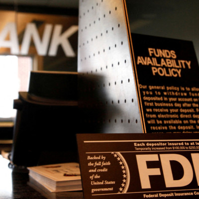 Signs explaining Federal Deposit Insurance Corporation (FDIC) and other banking policies are shown on the counter of a bank in Westminster