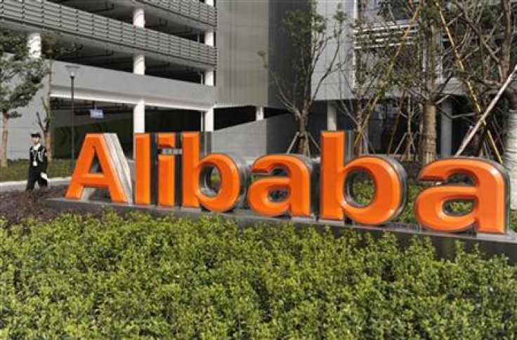 A security guard walks past a logo of Alibaba (China) Technology Co. Ltd at its headquarters on the outskirts of Hangzhou