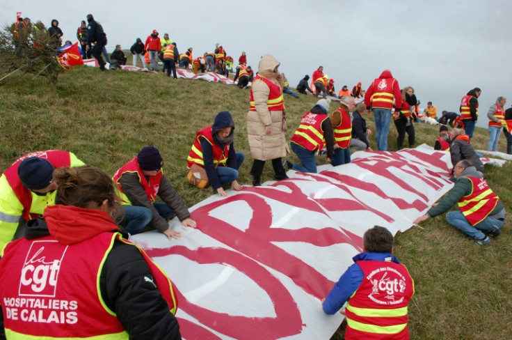 They battled clifftop winds to unfurl the banner so it could be easily seen from the coast