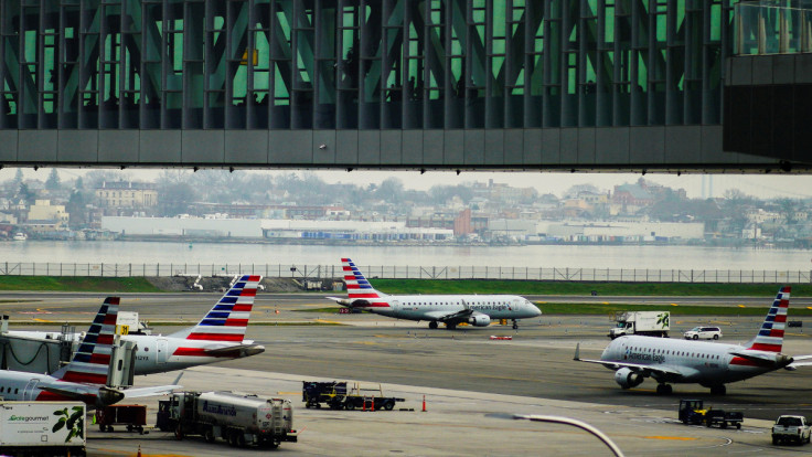 Planes are seen on the tarmac as travelers walk inside LaGuardia airport in New York