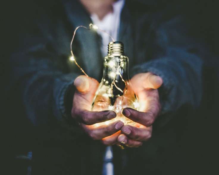 A man holding incandescent bulb