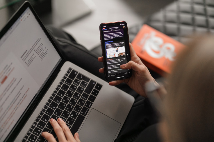 A woman working on PC and phone