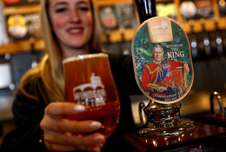 Bar worker Merryn Croft serves a glass of a coronation ale called Return Of The King