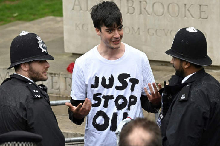 A protester from the climate protest group 'Just Stop Oil' is apprehended by police officers