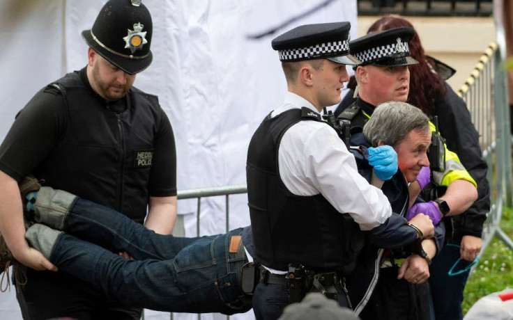 Policemen carry away protestor