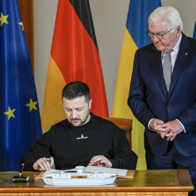 Ukraine's President Volodymyr Zelensky signs the guestbook at the Bellevue Palace before heading into talks with Germany's President Frank-Walter Steinmeier