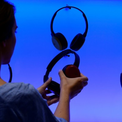 A woman poses at an installation showing headphones at the booth of JVC at the IFA (Internationale Funkausstellung) electronics trade fair in Berlin on September 1, 2016