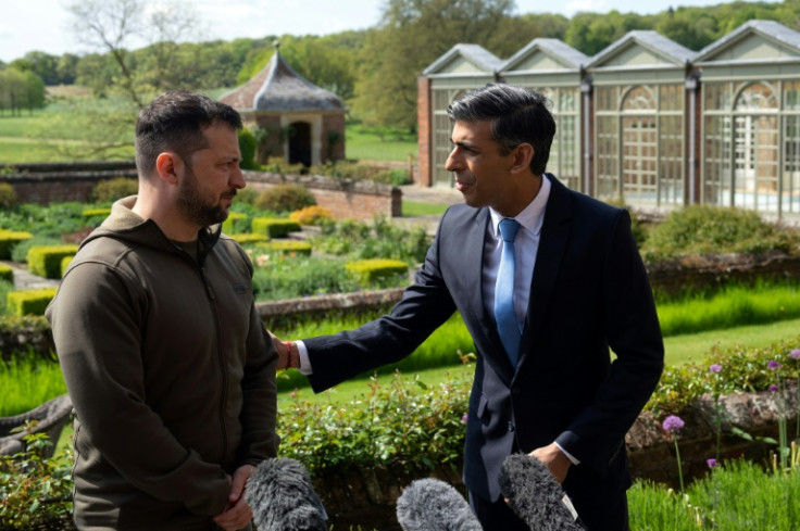 Britain's Prime Minister Rishi Sunak reaches out to Ukraine's President Volodymyr Zelensky during a joint press conference in the garden at Chequers