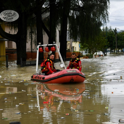 Volunteer firefighters ride their dinghy across a street flooded by the river Savio in the Ponte Vecchio district of Cesena, central eastern Italy, on May 17, 2023