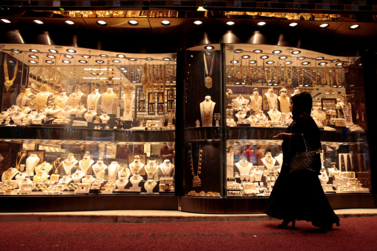 A woman walks past gold jewellery displayed in a shop window at the Gold Souq in Dubai