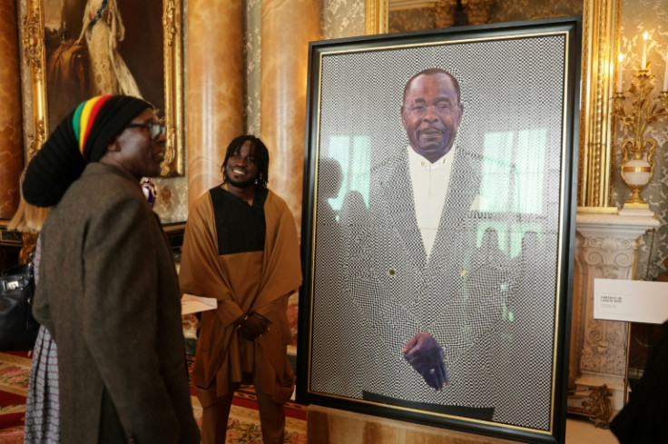 Guests look at a portrait of Laceta Reid during a reception to celebrate the Windrush Generation at Buckingham Palace