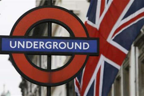 A Union Flag flies near an underground sign for Westminster tube station in London