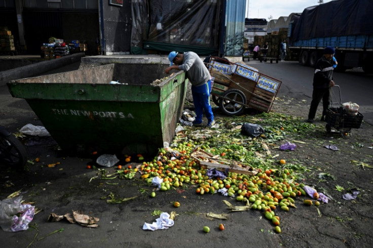 A man searches for food inside a trash can where discarded fruits and vegetables are deposited at the Central Market in Buenos Aires -- food insecurity is still a major global issue
