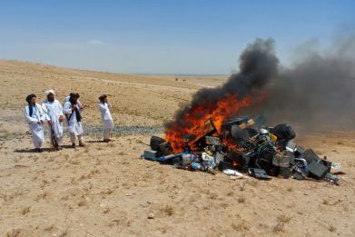 Members of Taliban set fire to a pile of musical instruments and equipment on the outskirts of Herat