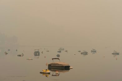 Boats sit amongst smoke from the nearby Bush Creek East Wildfire on Shuswap Lake in Gleneden, British Columbia. Two fast-moving "extreme" wildfires merged overnight in western Canada, threatening hundreds more homes and forcing continued evacuations in a 